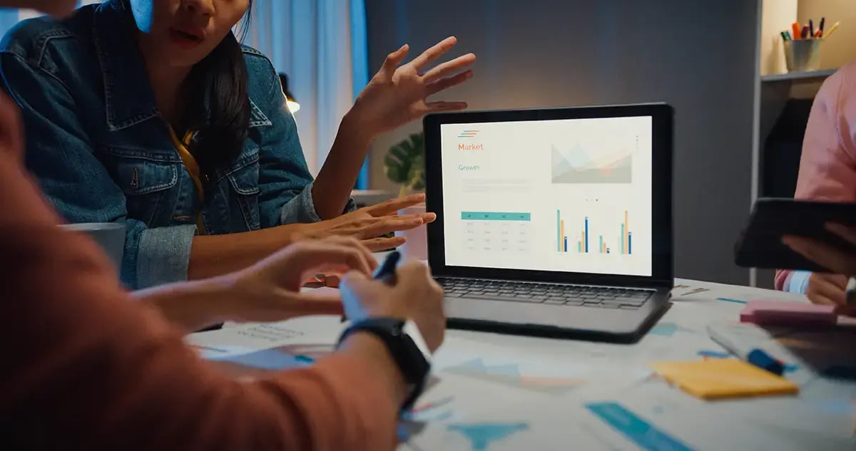 une équipe de commercialisation discute de stratégie revops autour d'un tableau de bord