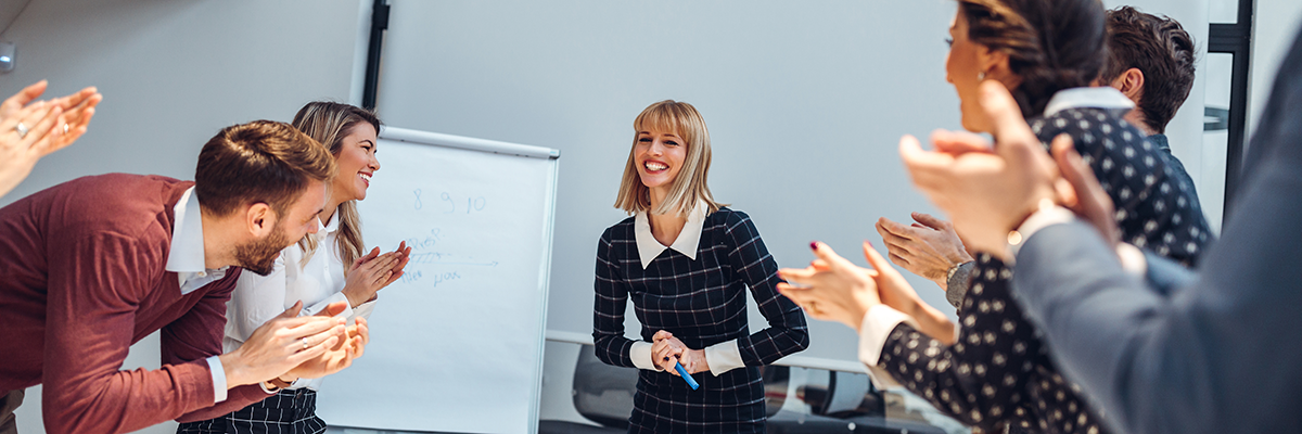 des collègues applaudissent une présentatrice